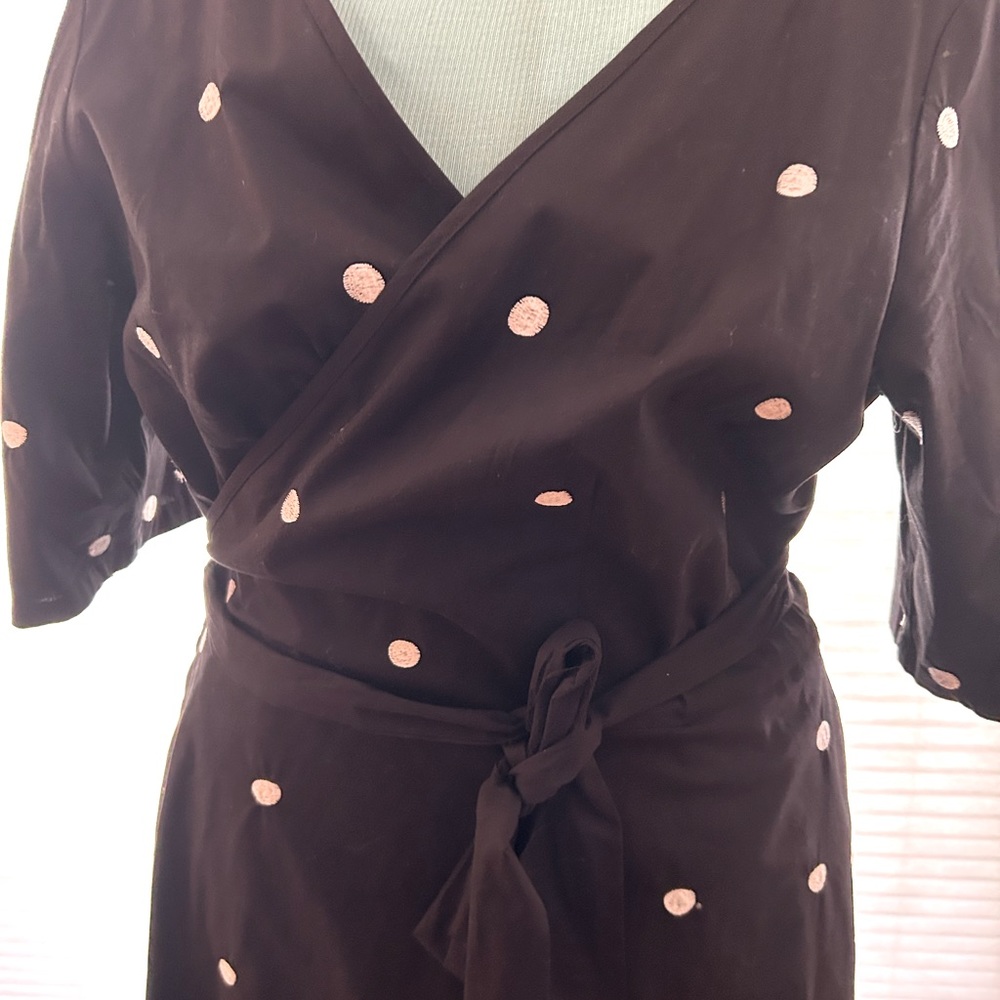 Black poplin wrap dress with embroidered polkadots. Elbow length sleeves.